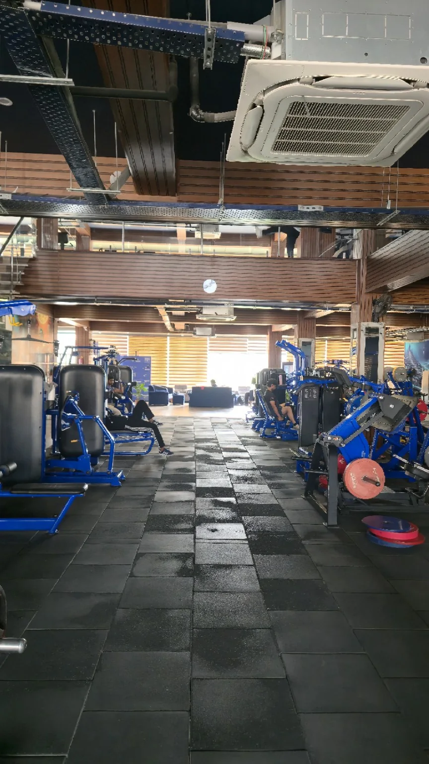 Blue resistance machines beneath the double-height gym atrium