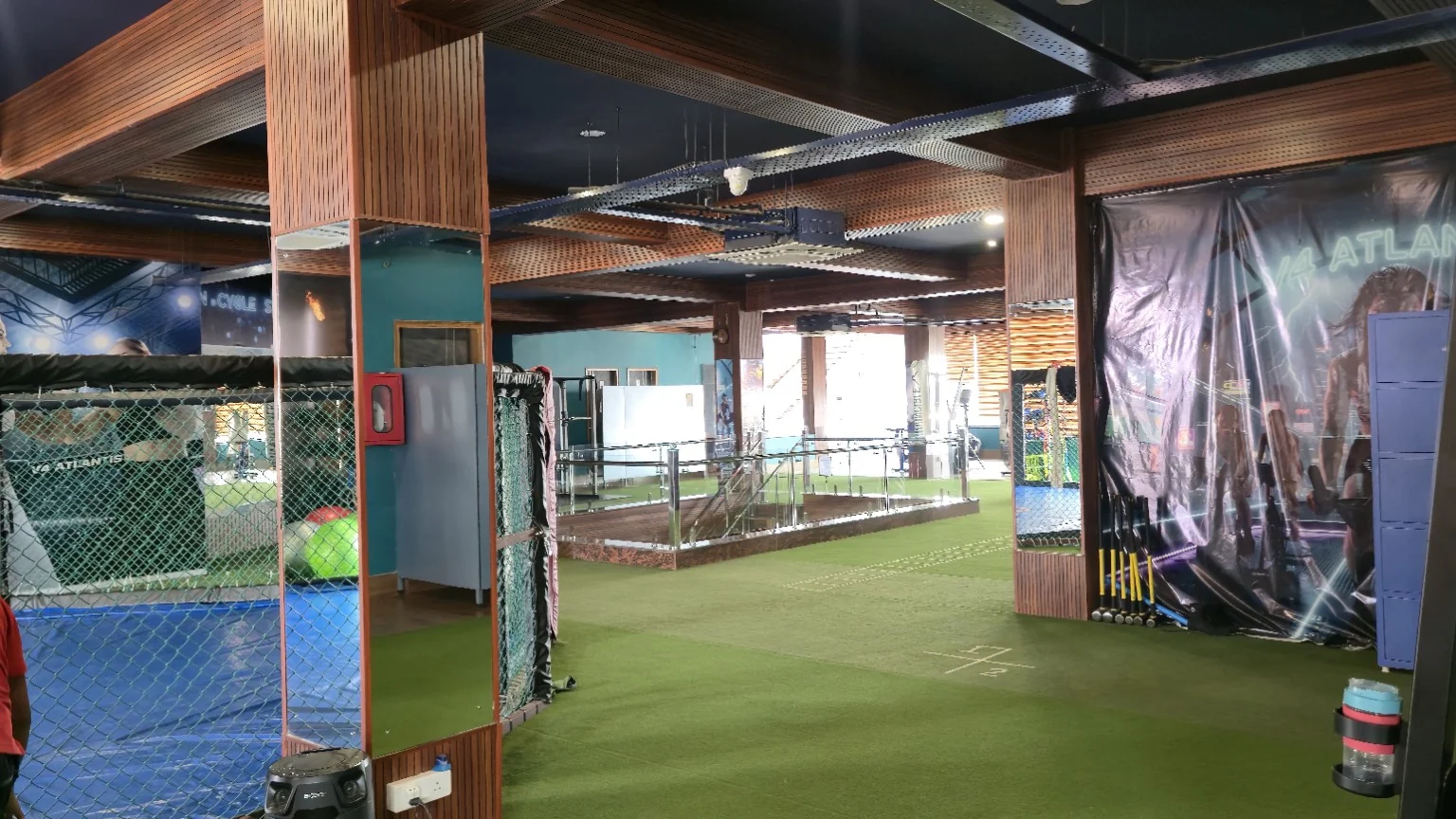 Open upper training floor with green turf, mirrored columns and atrium