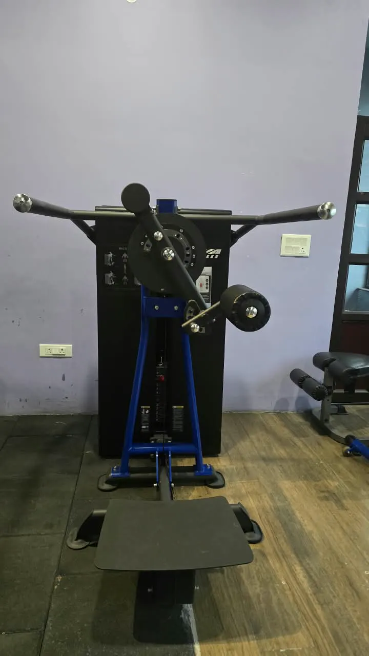 Blue and black rotary torso machine against a pale wall