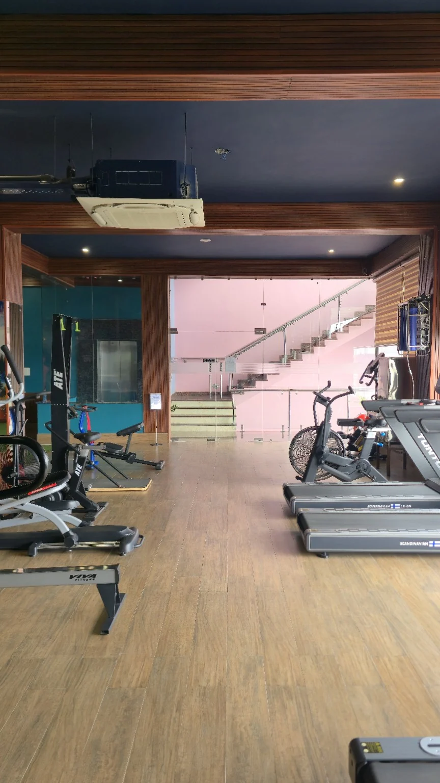 Treadmills and air bikes beside the stairwell and glass doors