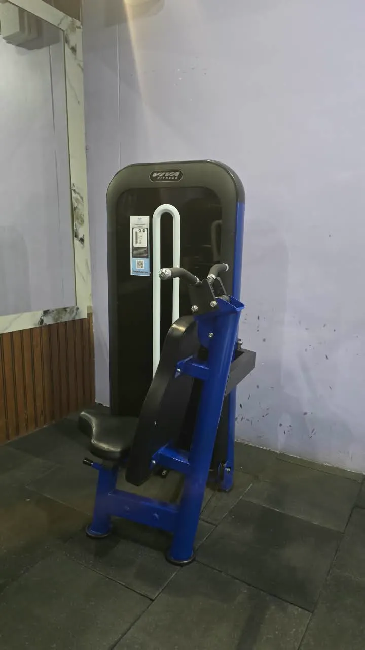 Blue and black seated dip machine with black upholstery in a corner beside a marble-clad wall
