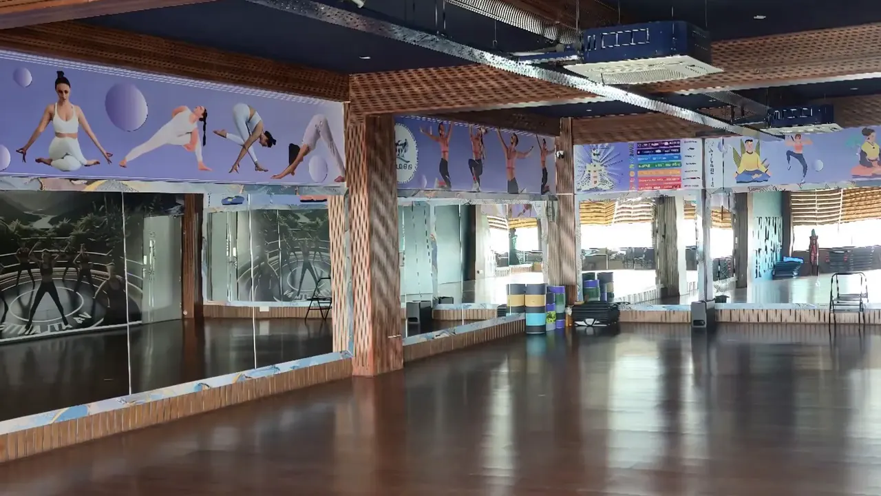 Mirrored yoga and group-class studio with timber flooring, yoga wall graphics and neatly stacked equipment